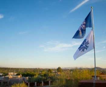 Pima flags flying with view of Tucson